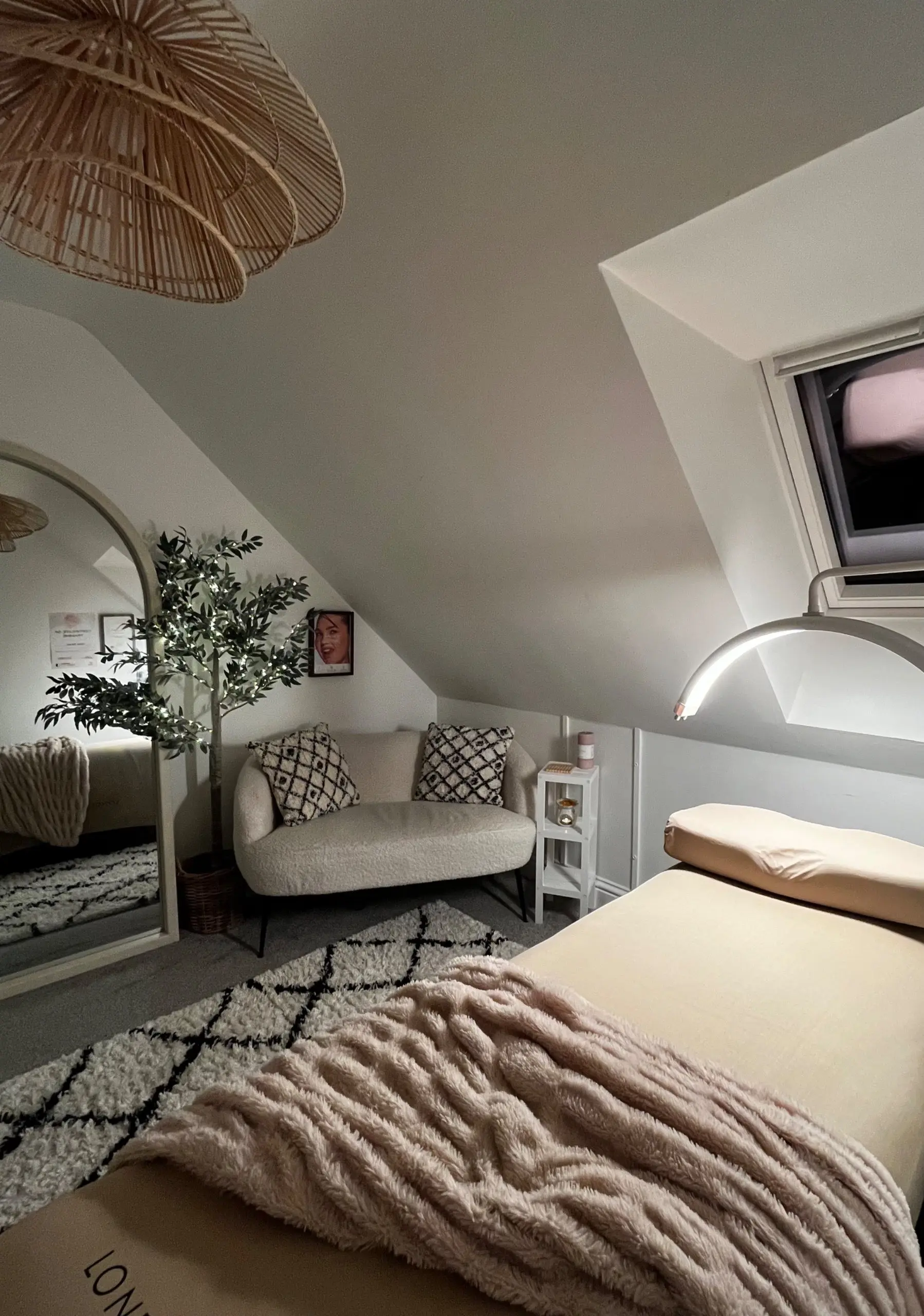 The treatment room with sofa, lash bed and arched mirror