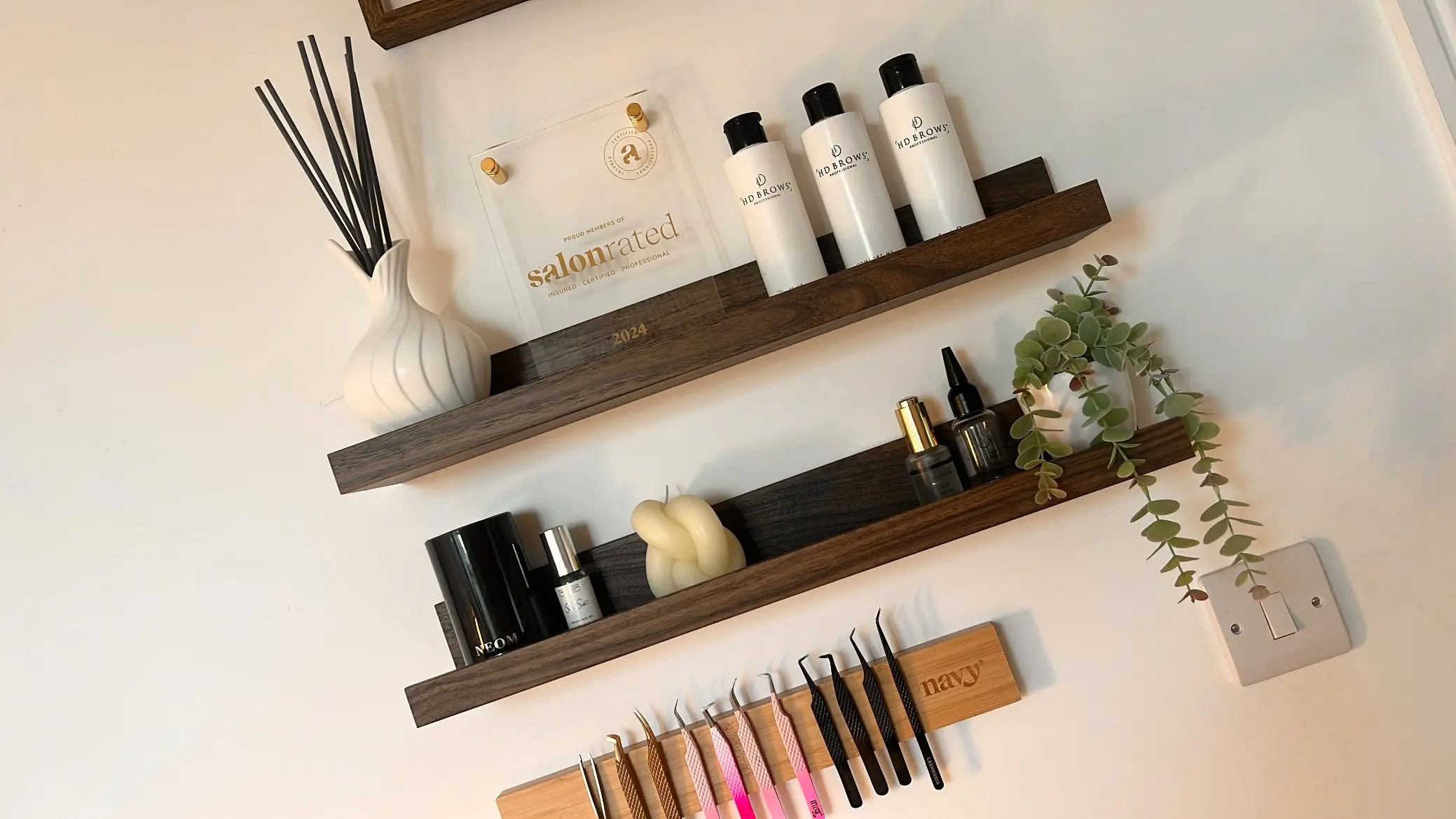 Floating shelves with lash products, diffuser and tweezer rack