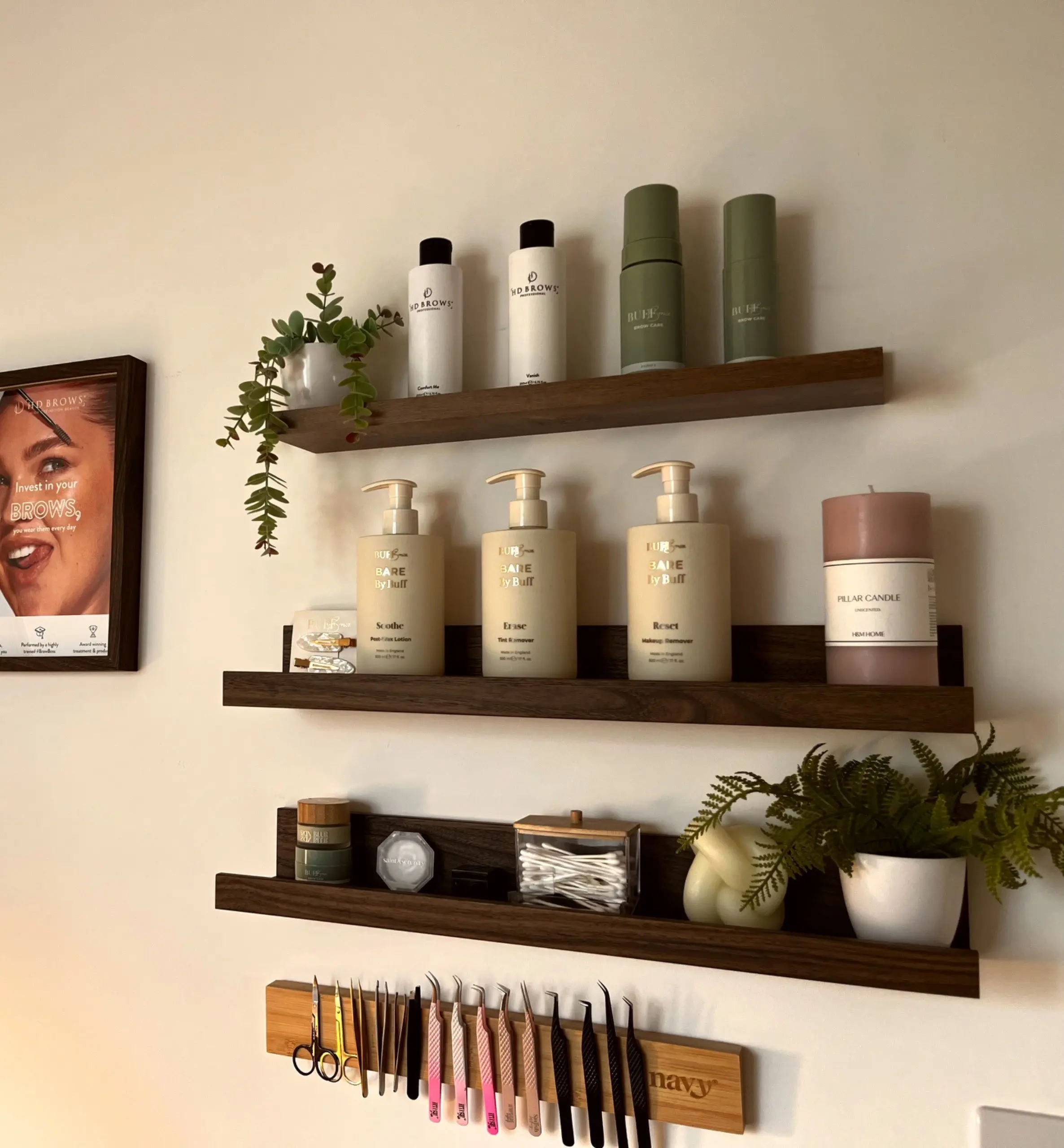 Floating shelves with lash products and tweezers